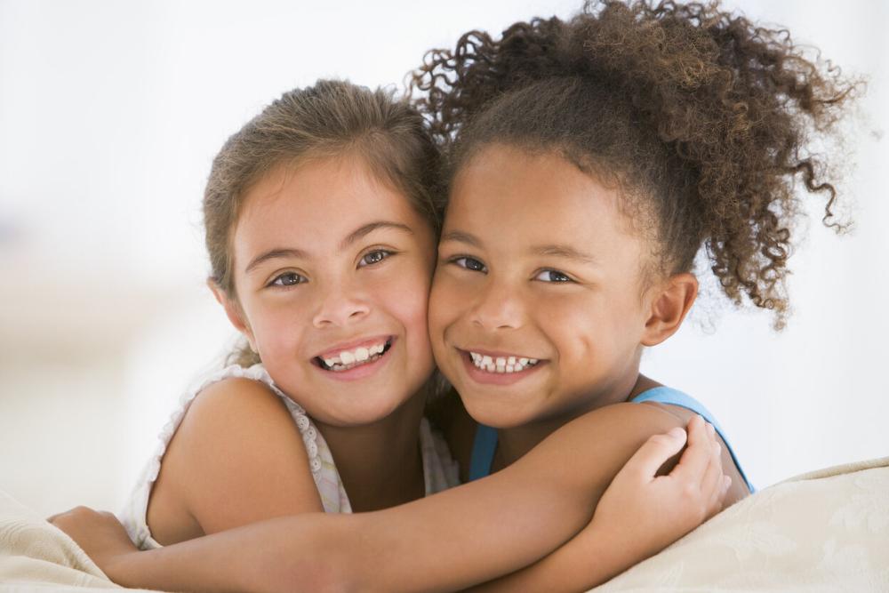 two young girls smiling and hugging