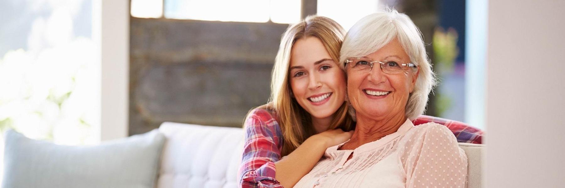 older woman and her daughter smiling on the couch