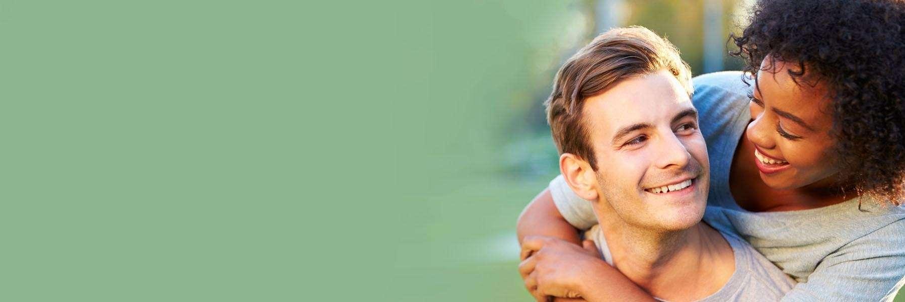 woman hugging man's shoulders from behind